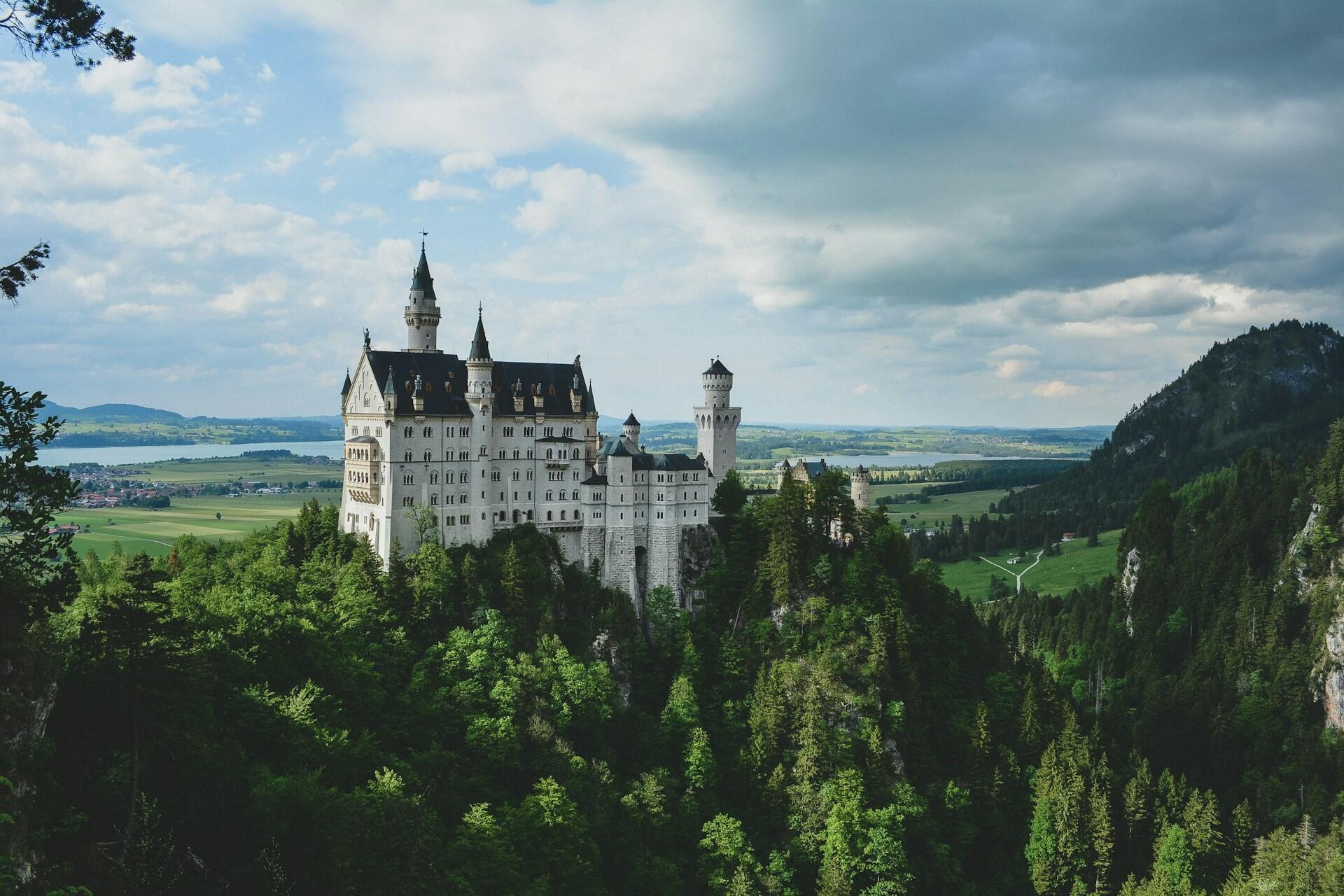Neuschwanstein Castle surrounded by forest and mountains in Germany