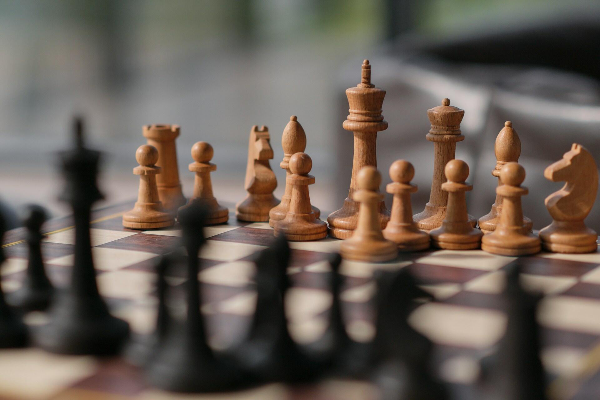 hess pieces arranged on a chess board during the opening stage of a game