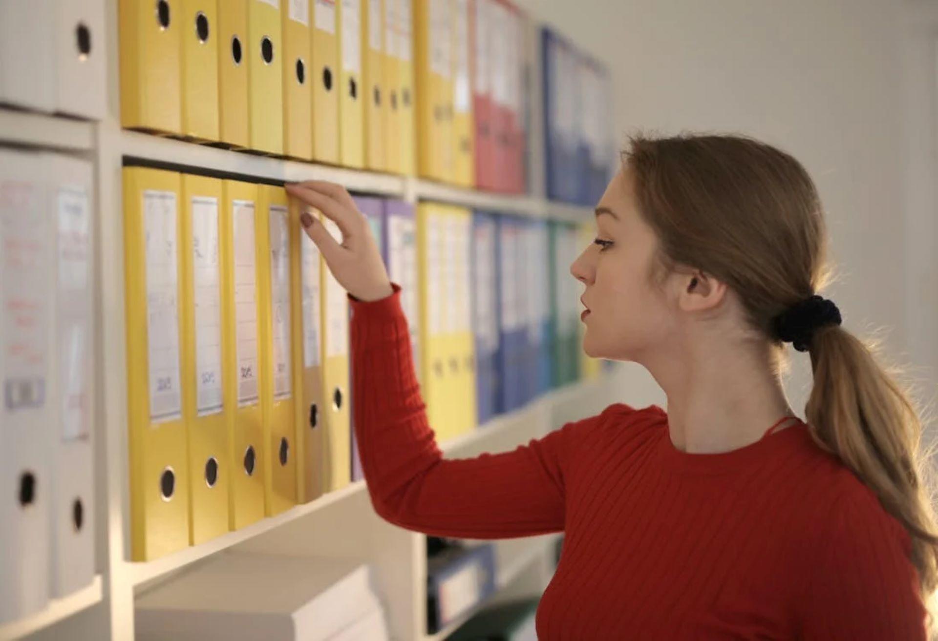 Woman organizing folders on a shelf