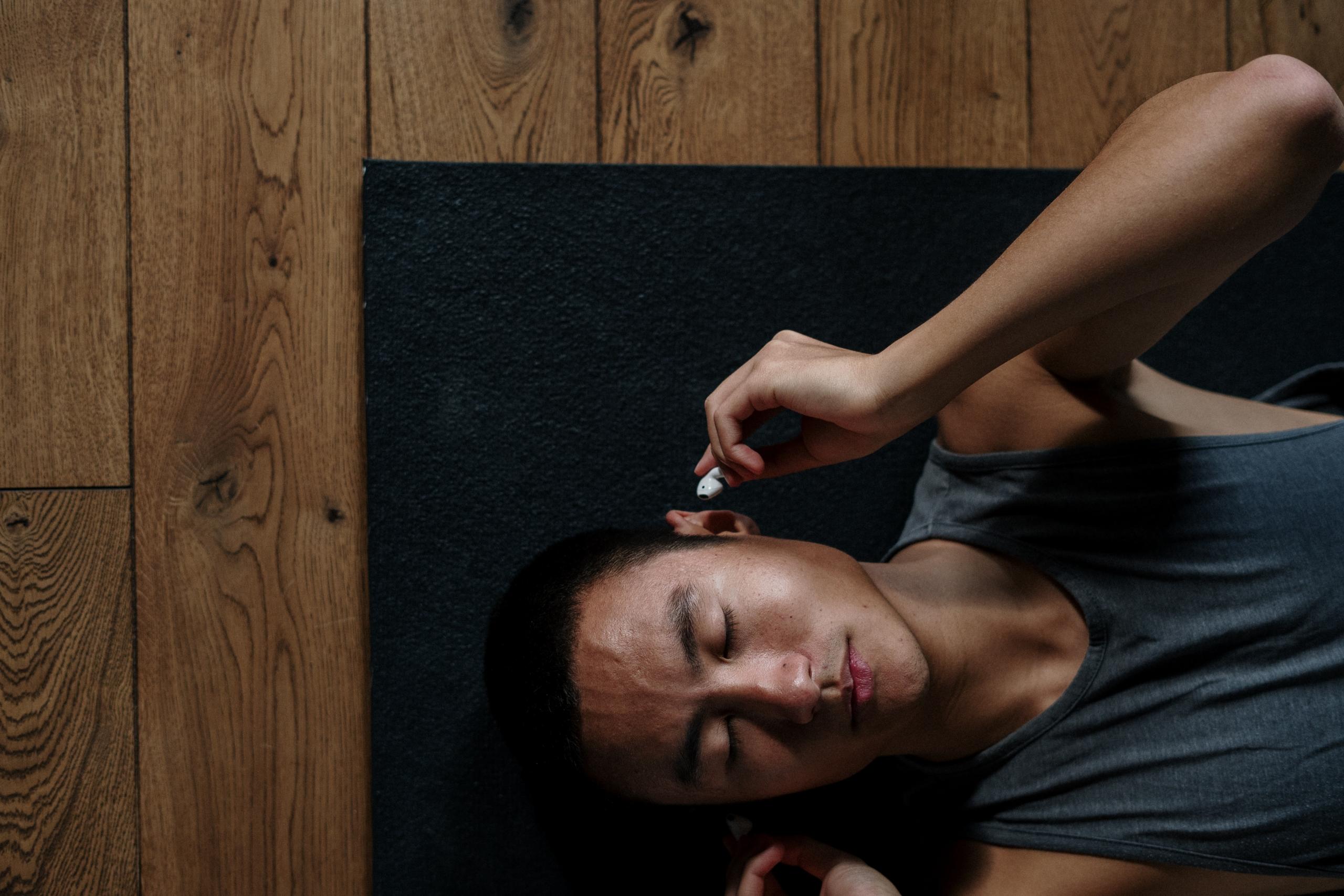 A man listening to some guided meditations while practicing yoga.