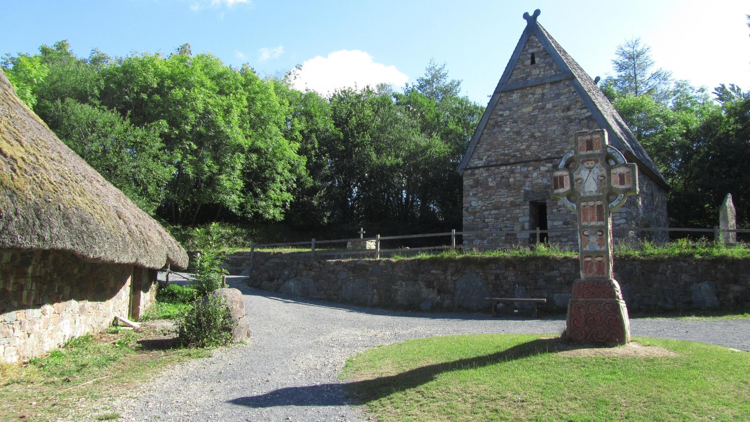 A village centre in Ireland with a cross and two historic buildings