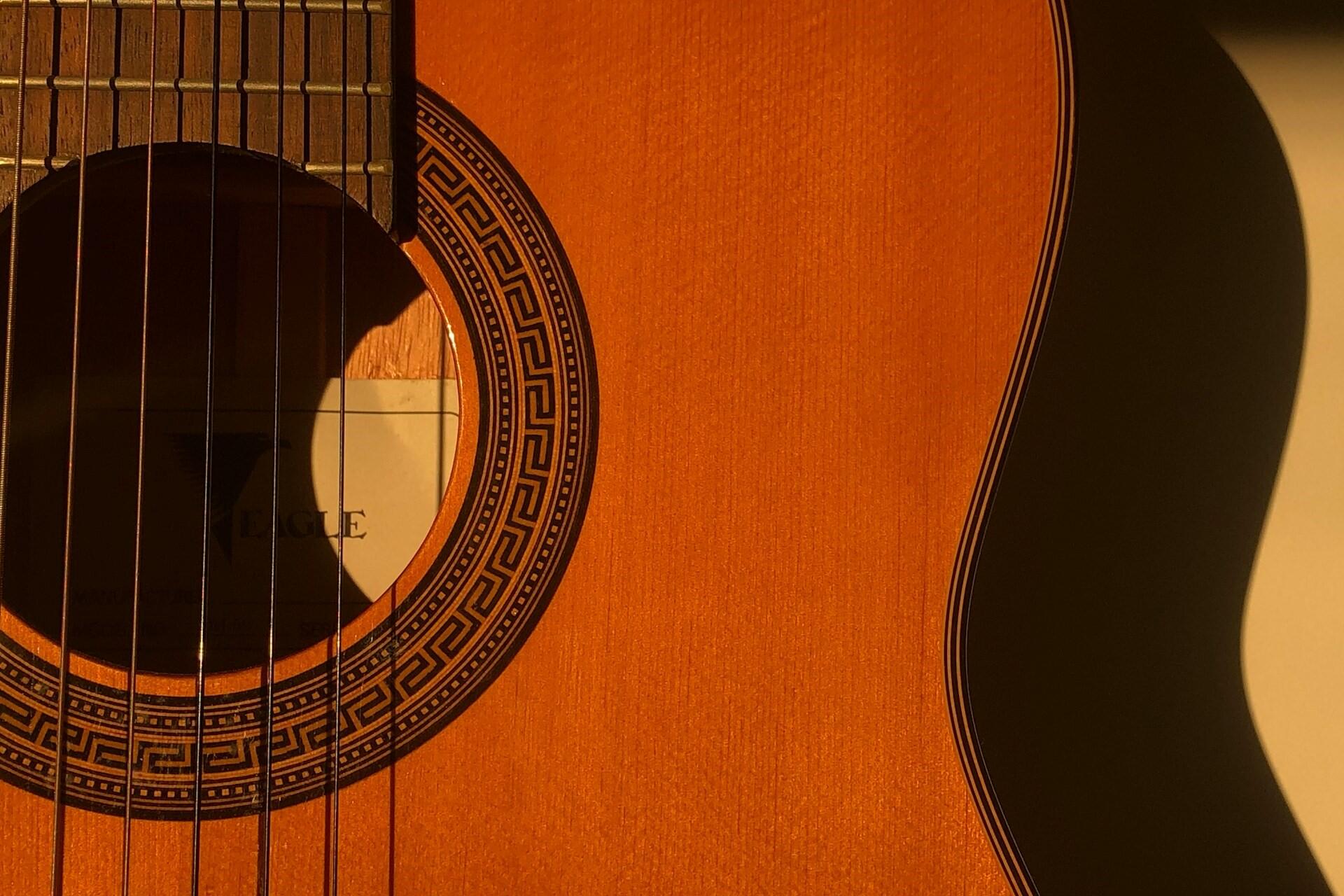 close-up of acoustic guitar body showing wood grain and sound hole detail