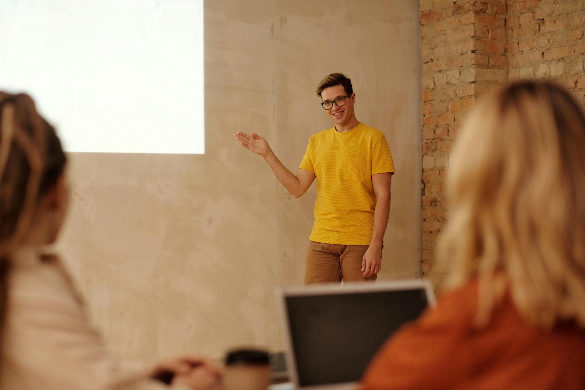 Man in yellow shirt giving an enthusiastic presentation