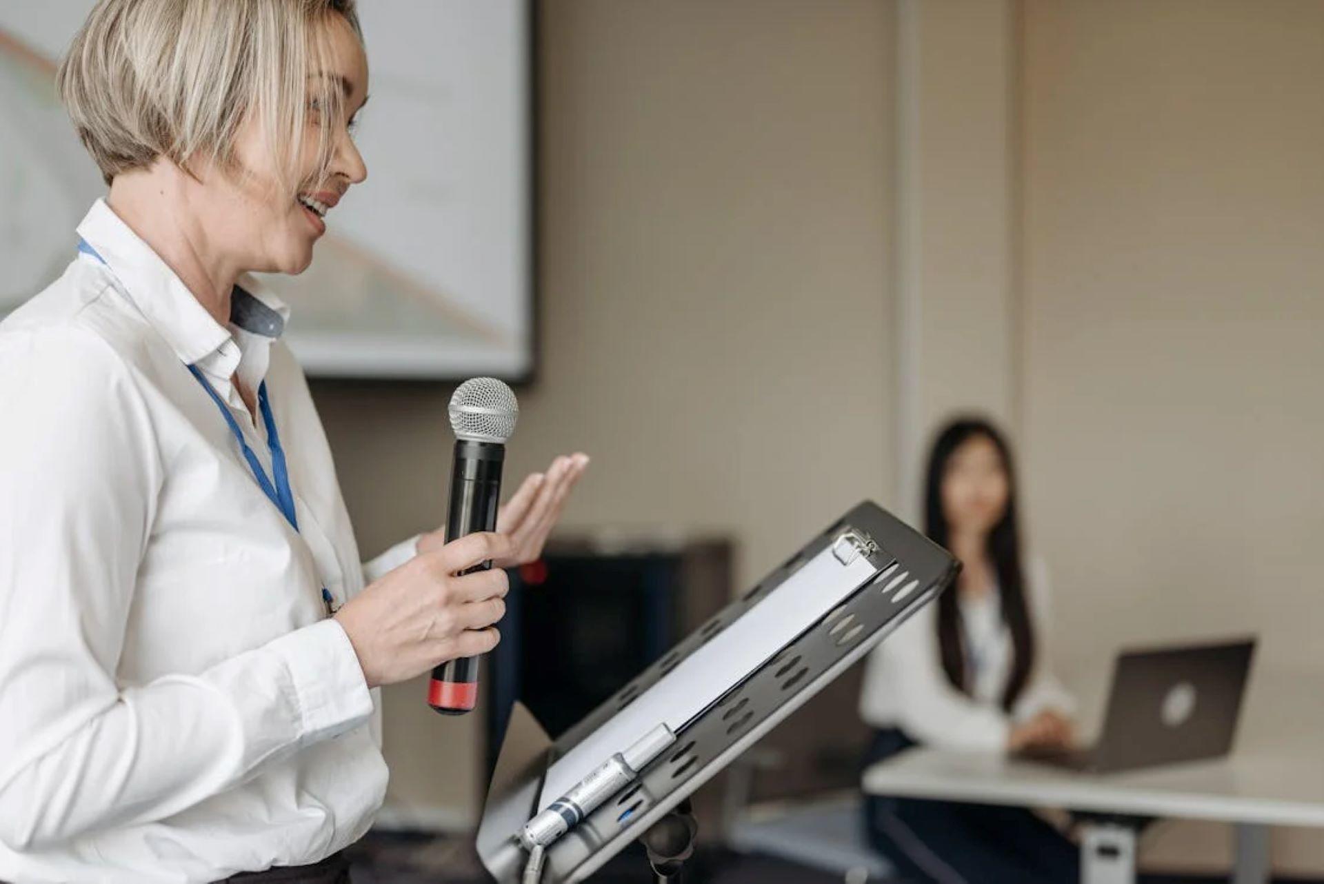 Woman with microphone presenting in a conference room