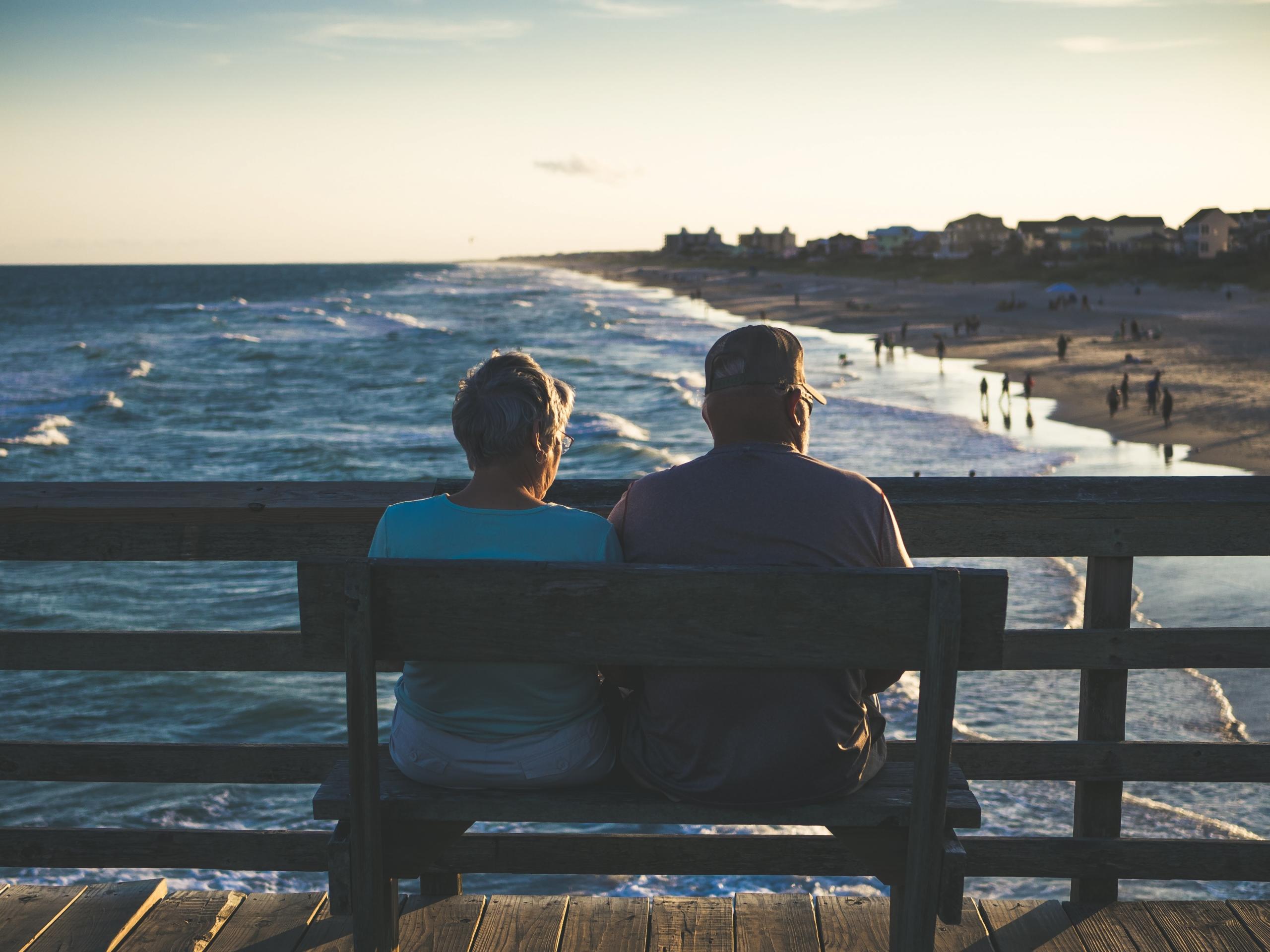 A senior couple sitting on a bench enjoying retirement