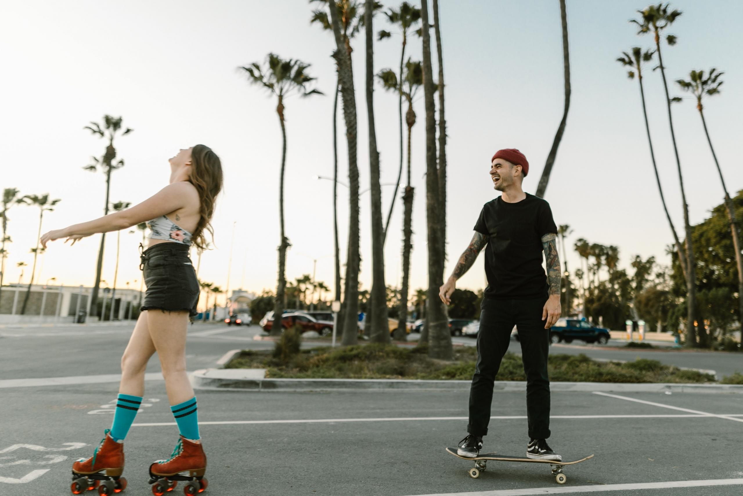 Two people roller skating and skateboarding