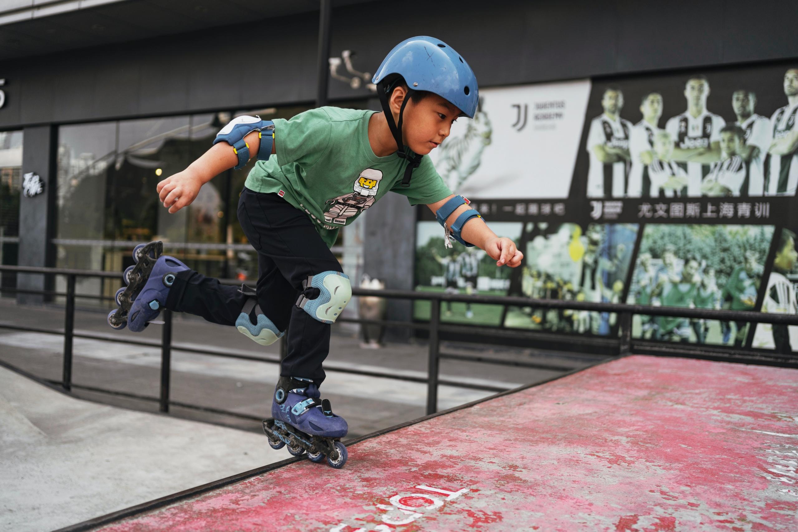 Young child roller skating wearing a helmet
