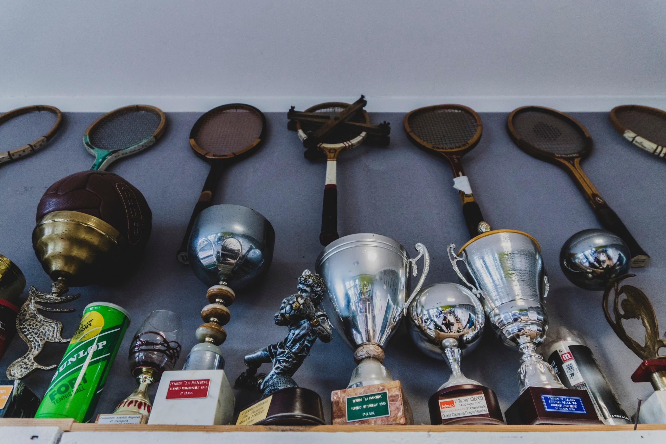 A display of trophies along with tennis rackets