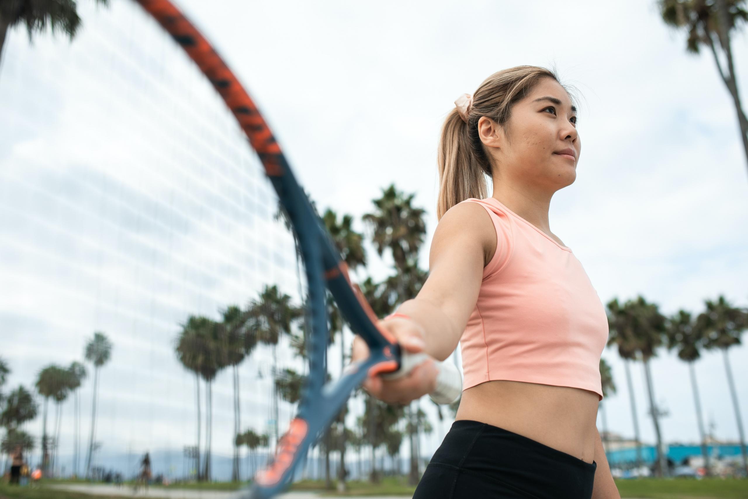 A young lady holding her tennis racket