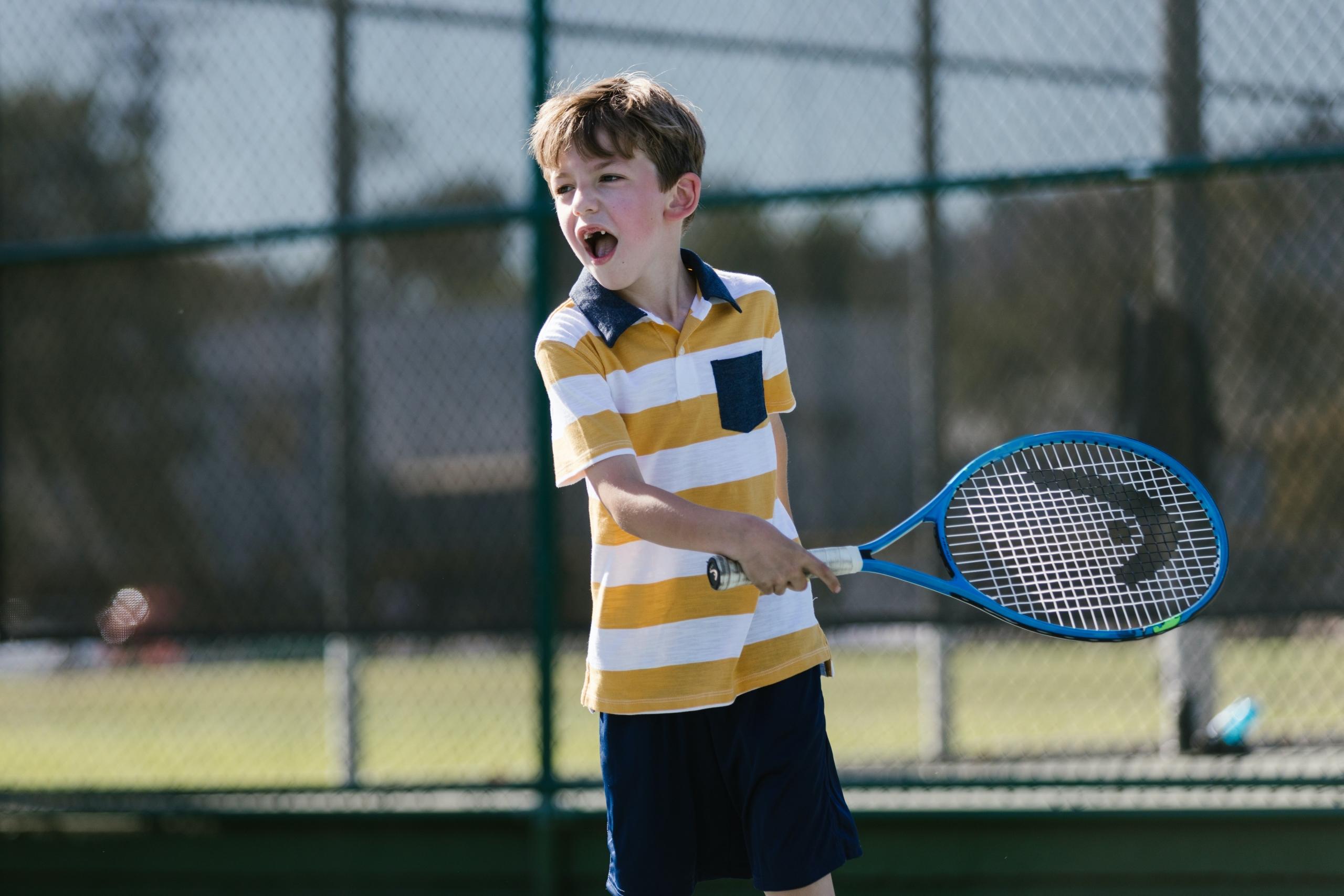 A young boy playing a game of tennis