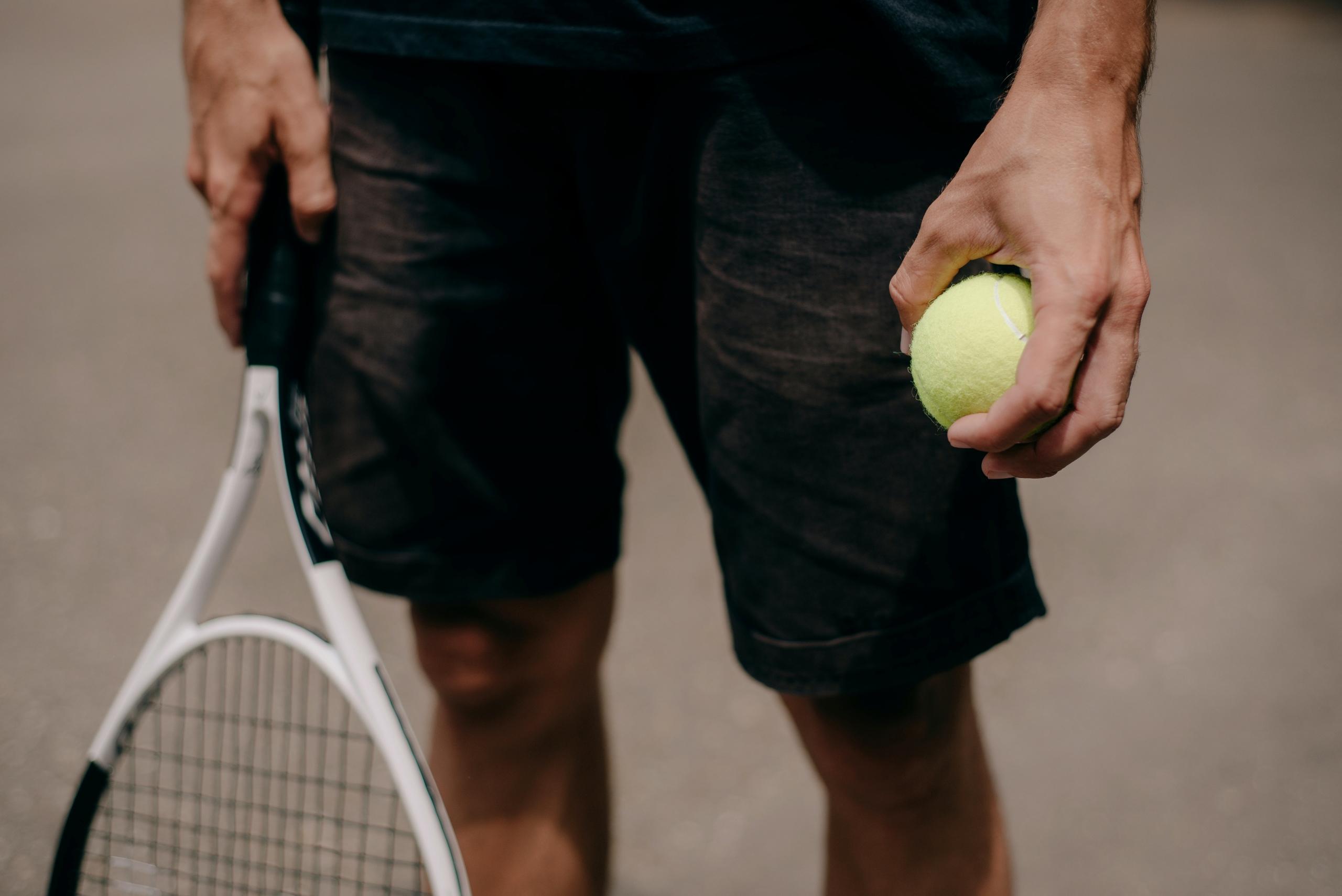 A tennis player holding a tennis racket and tennis ball