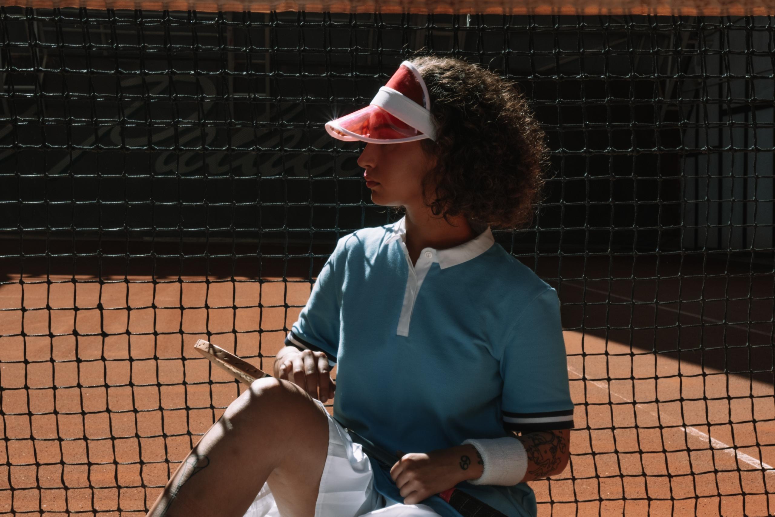 Tennis player gripping a racket, poised for action on the court.