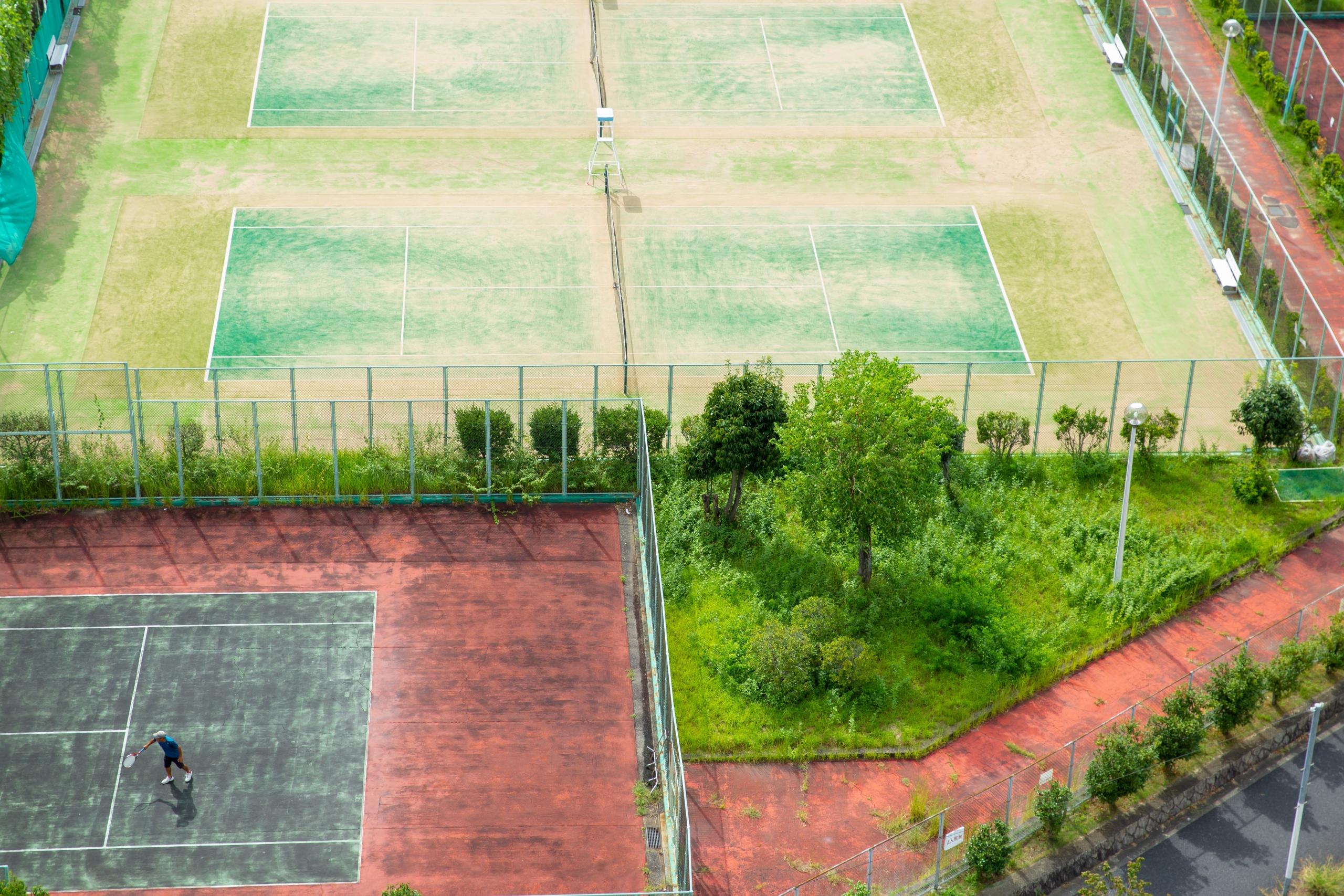 Drone shot of three tennis courts from above.