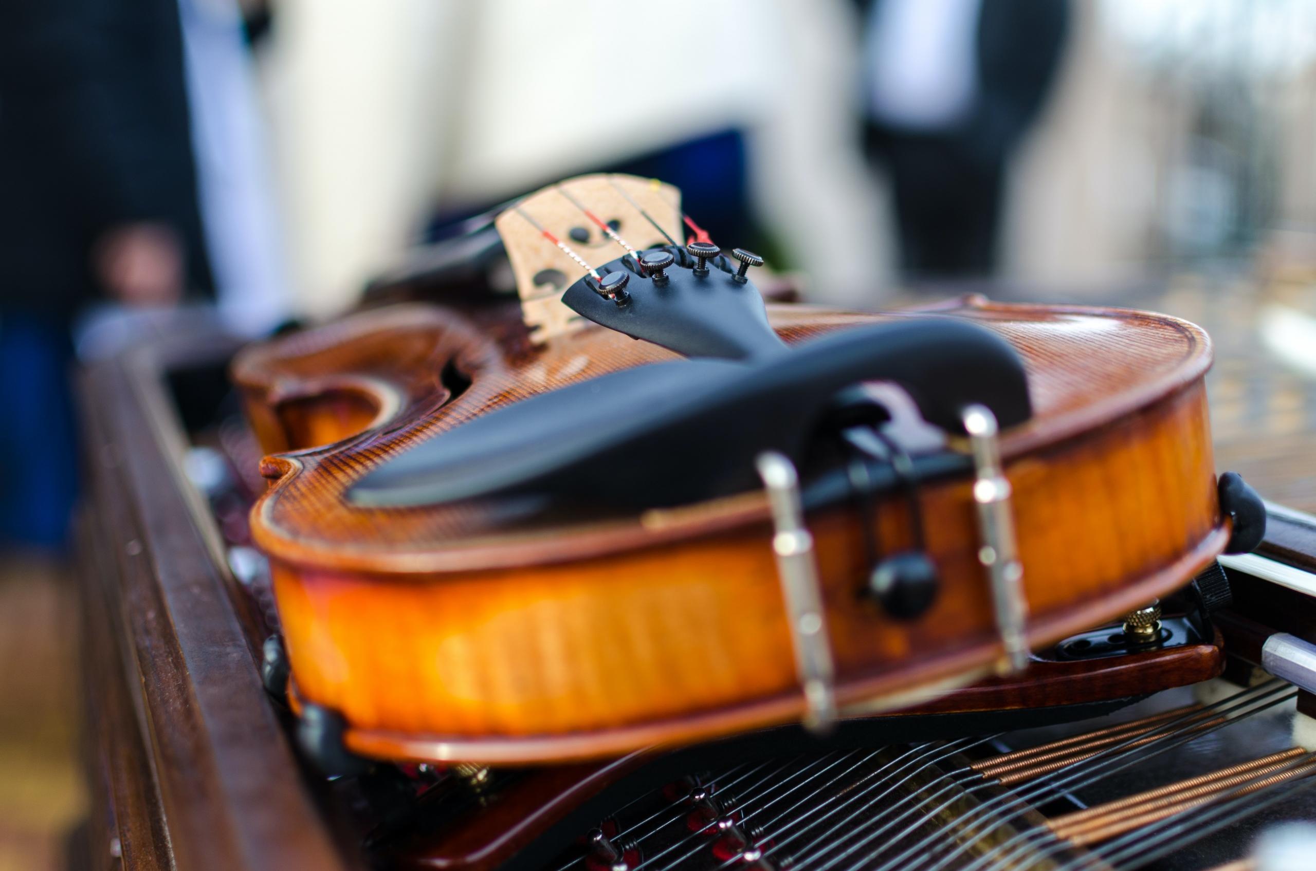 The intricate tailpiece of a violin, complemented by fine tuners, essential for maintaining pitch perfection.