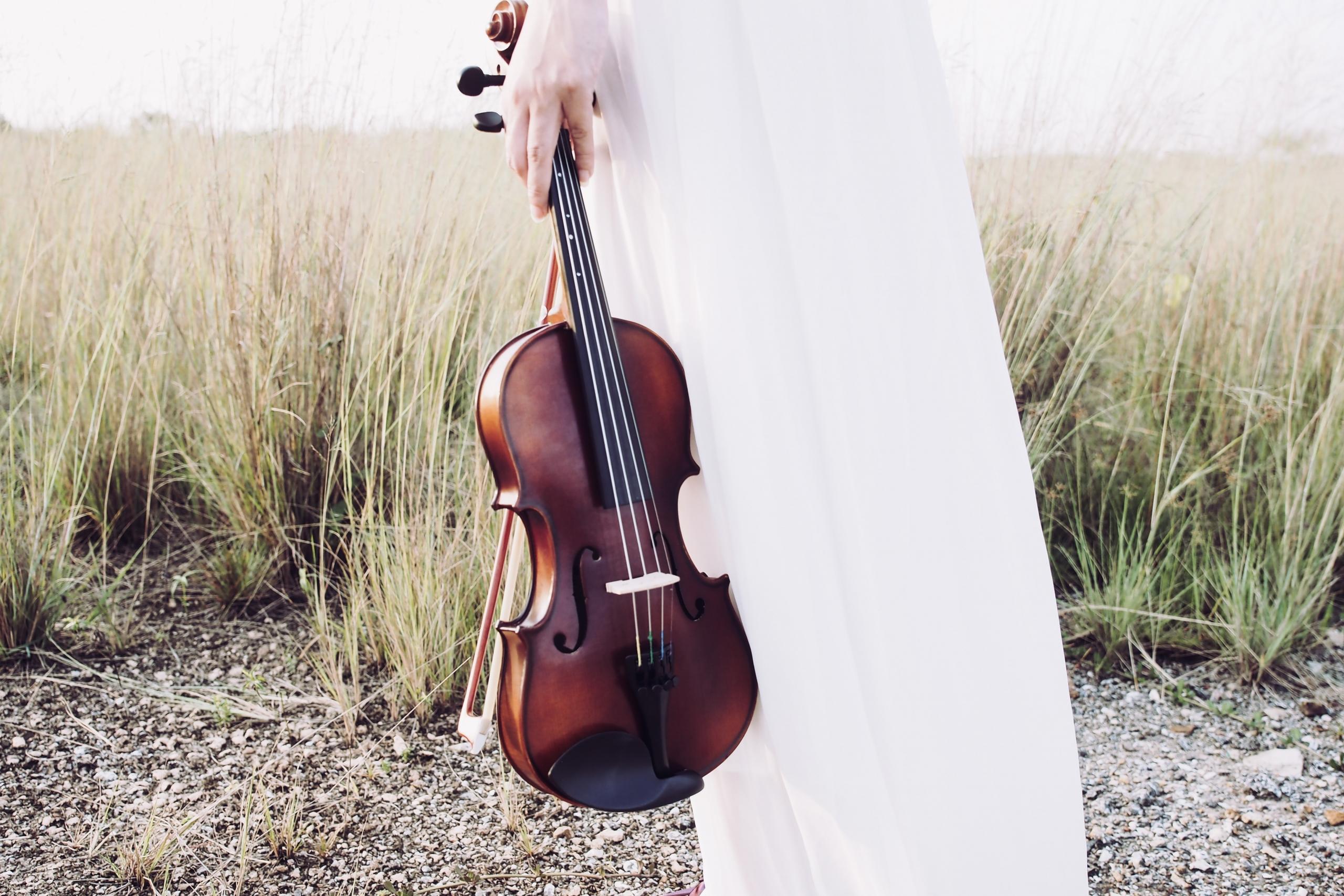 A close-up shot showcasing the intricate details of the scroll on a finely crafted violin, highlighting its exquisite woodwork.