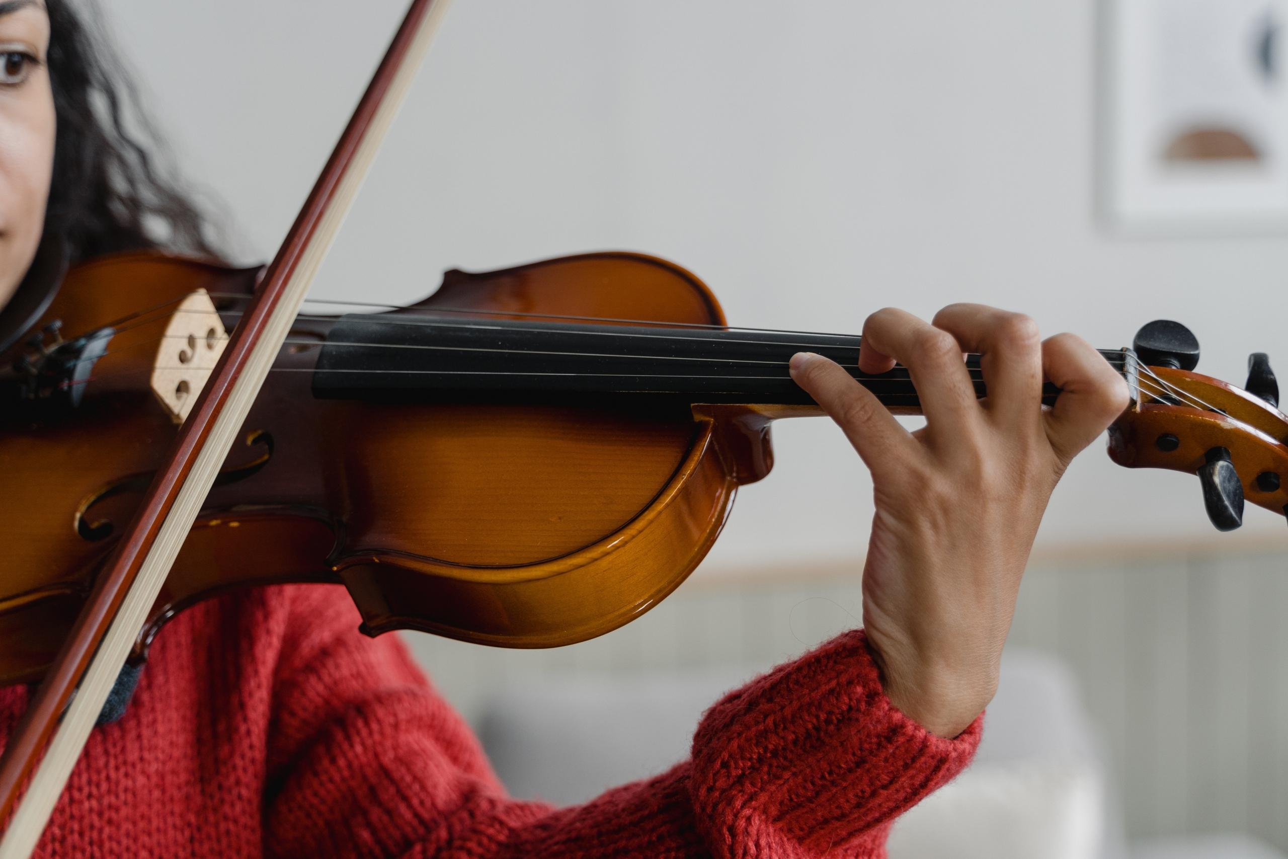 A mesmerizing view capturing the delicate strings and meticulously carved bridge of a classical violin, ready to produce enchanting melodies.