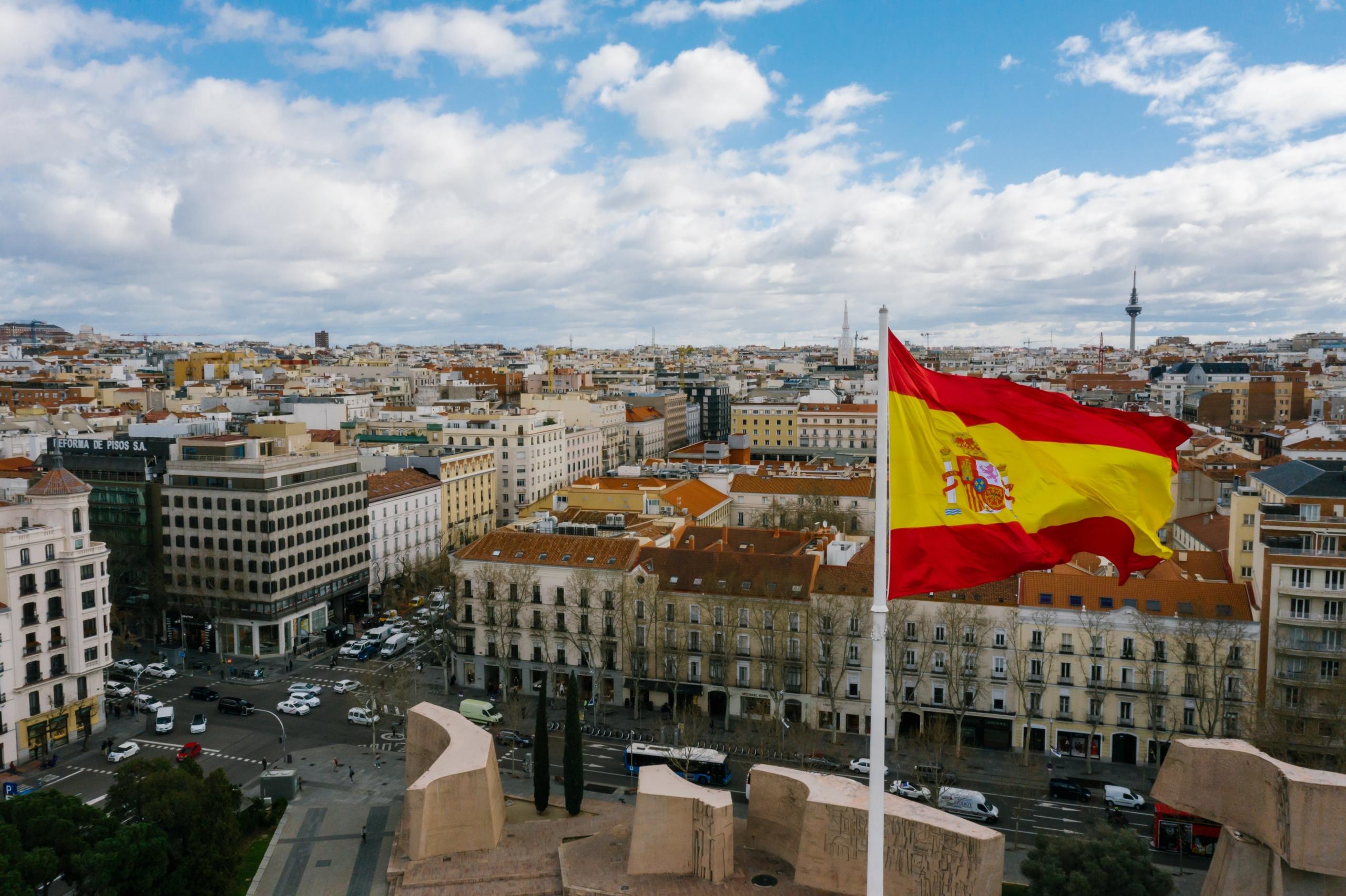 A Spanish flag flying high over the city.