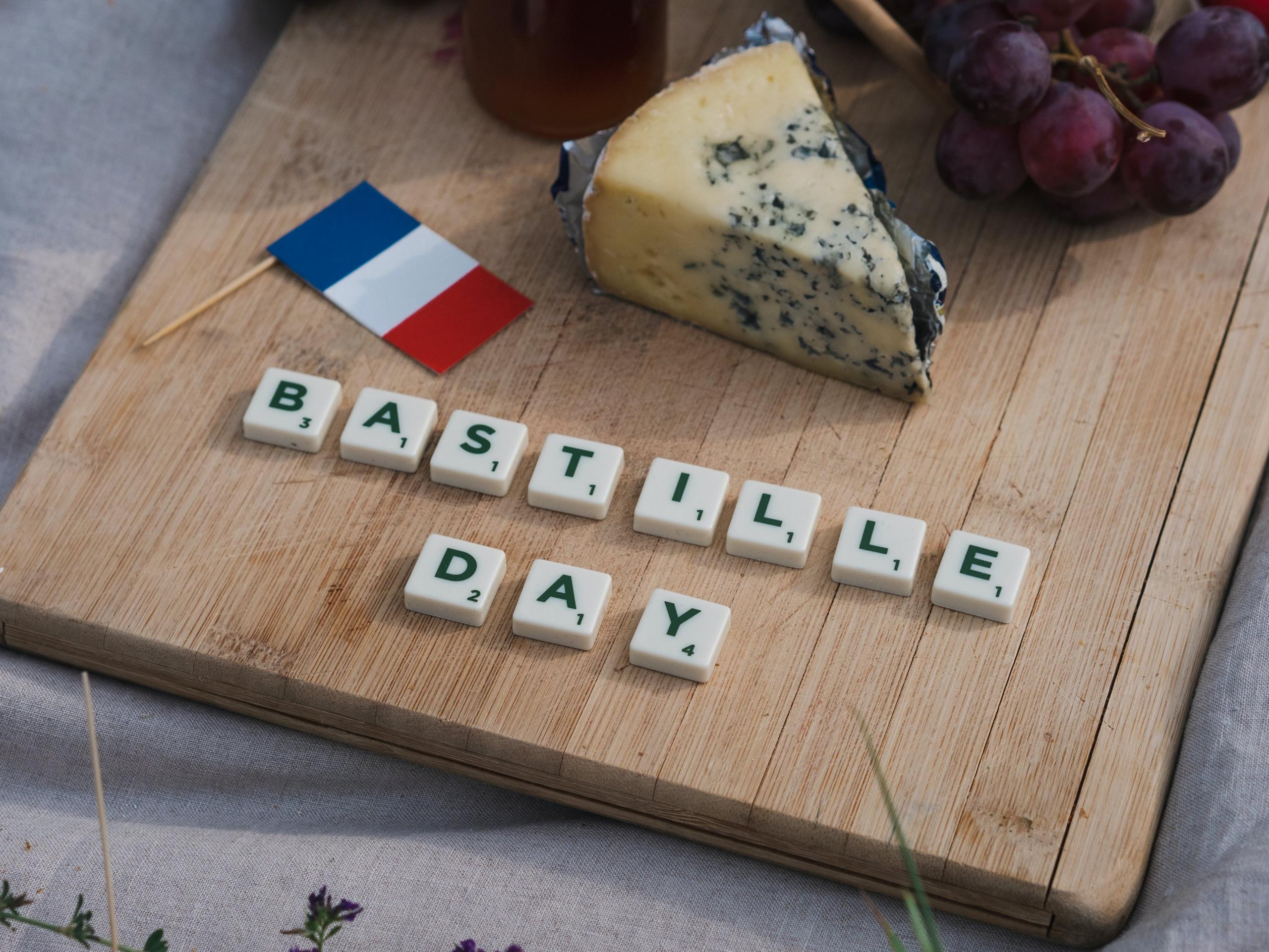 A spread of french pastries, wine and cheese in the park.