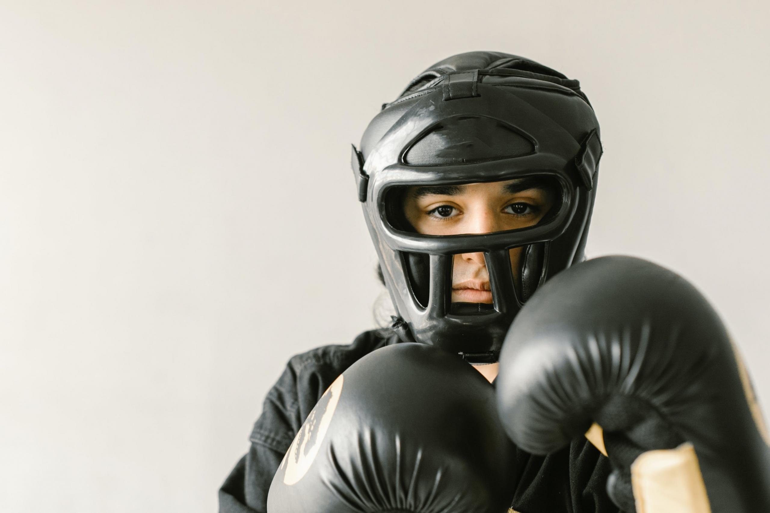 An immature fighter wearing headgear and gloves.
