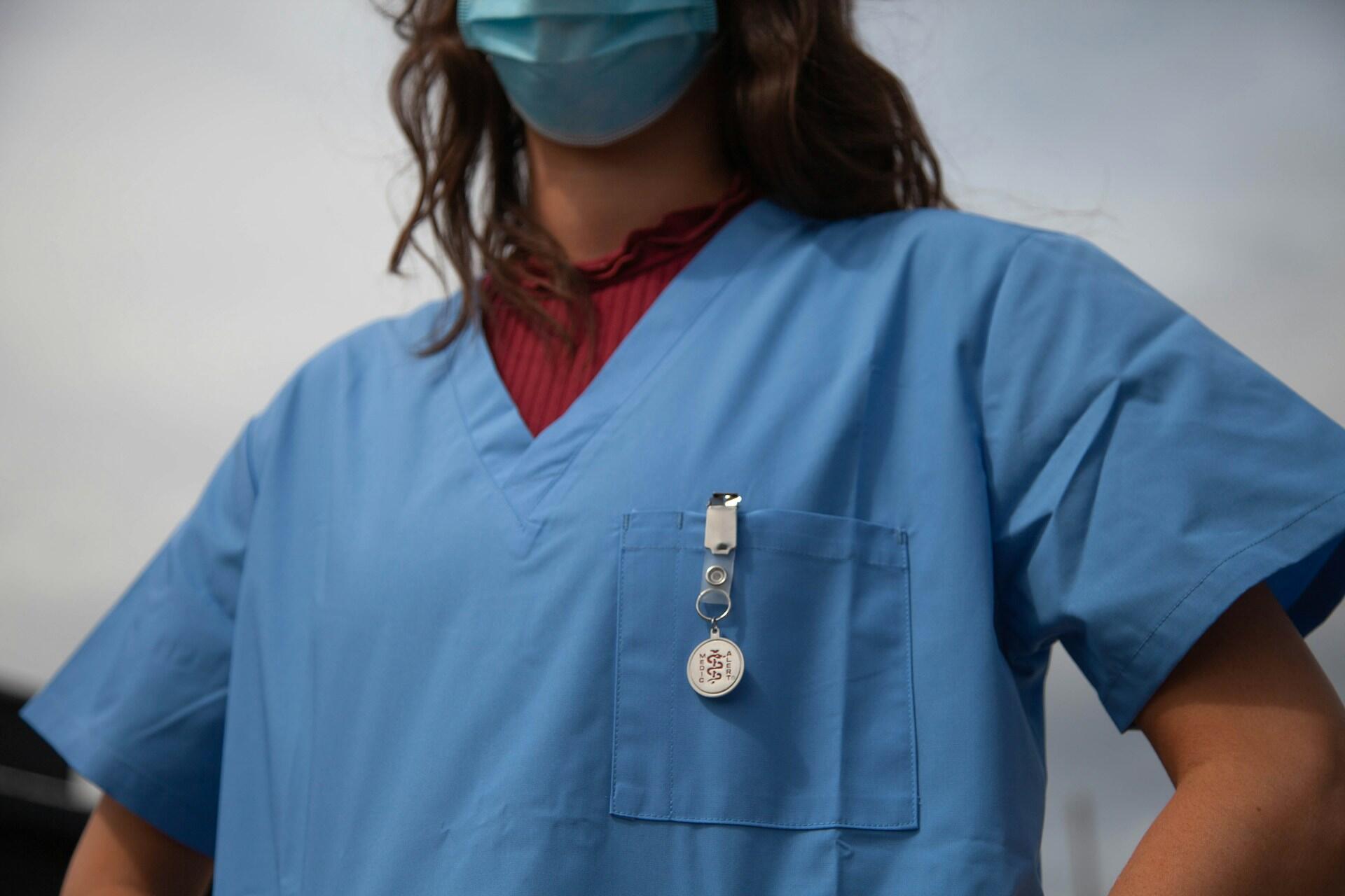 A nurse in a mask and scrubs.