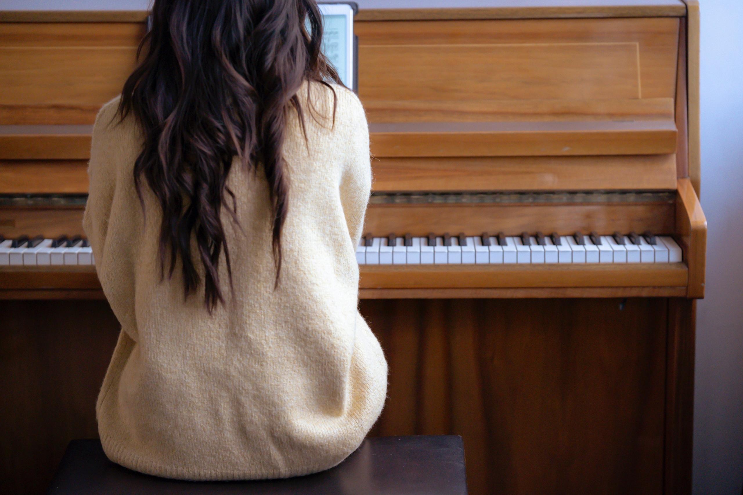 A music student brushing up on her piano.