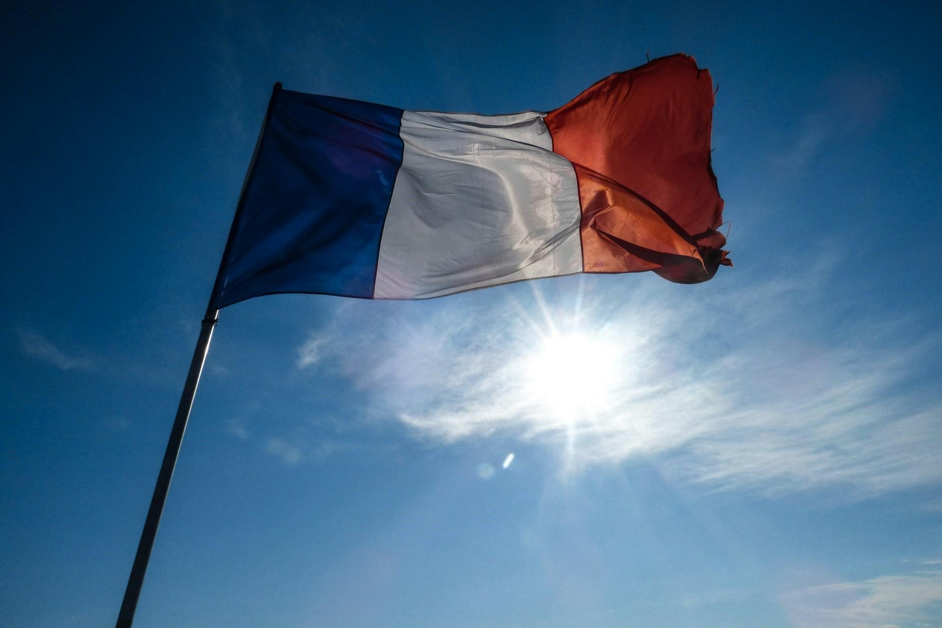 The French flag with the sun behind it.