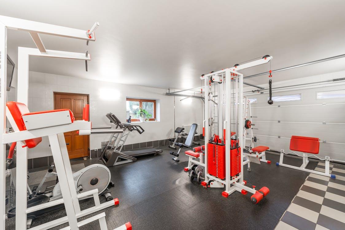 A home gym in the basement featuring a variety of workout equipment.