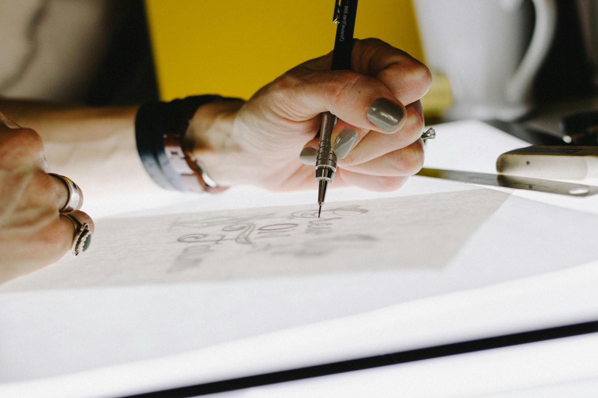 A graphic designer drawing using a lightbox.