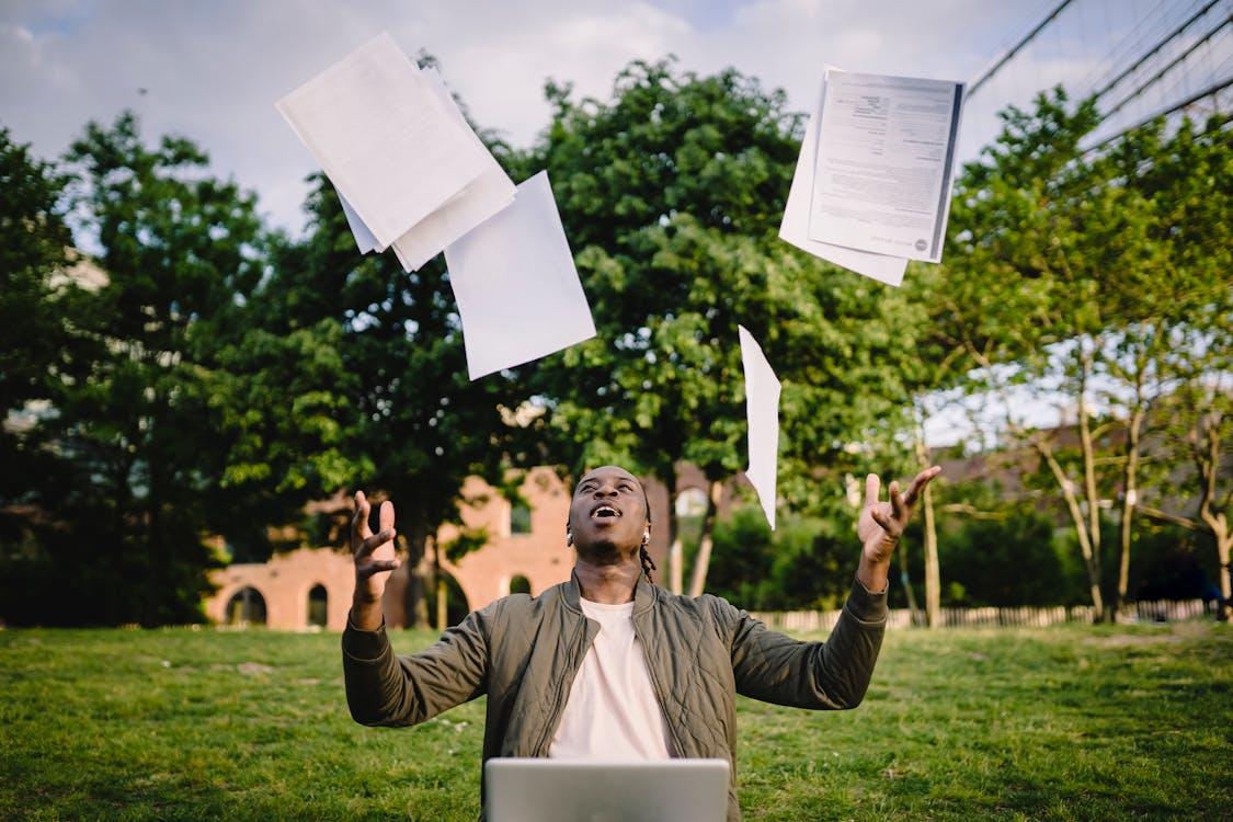 A university student throwing papers in the air.