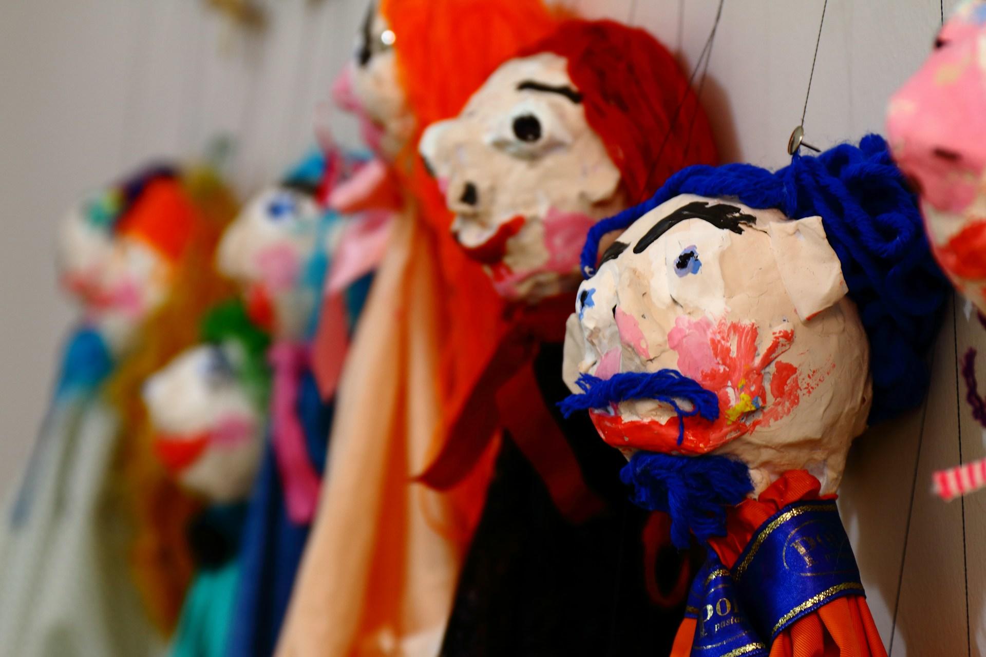 A number of painted marionettes.
