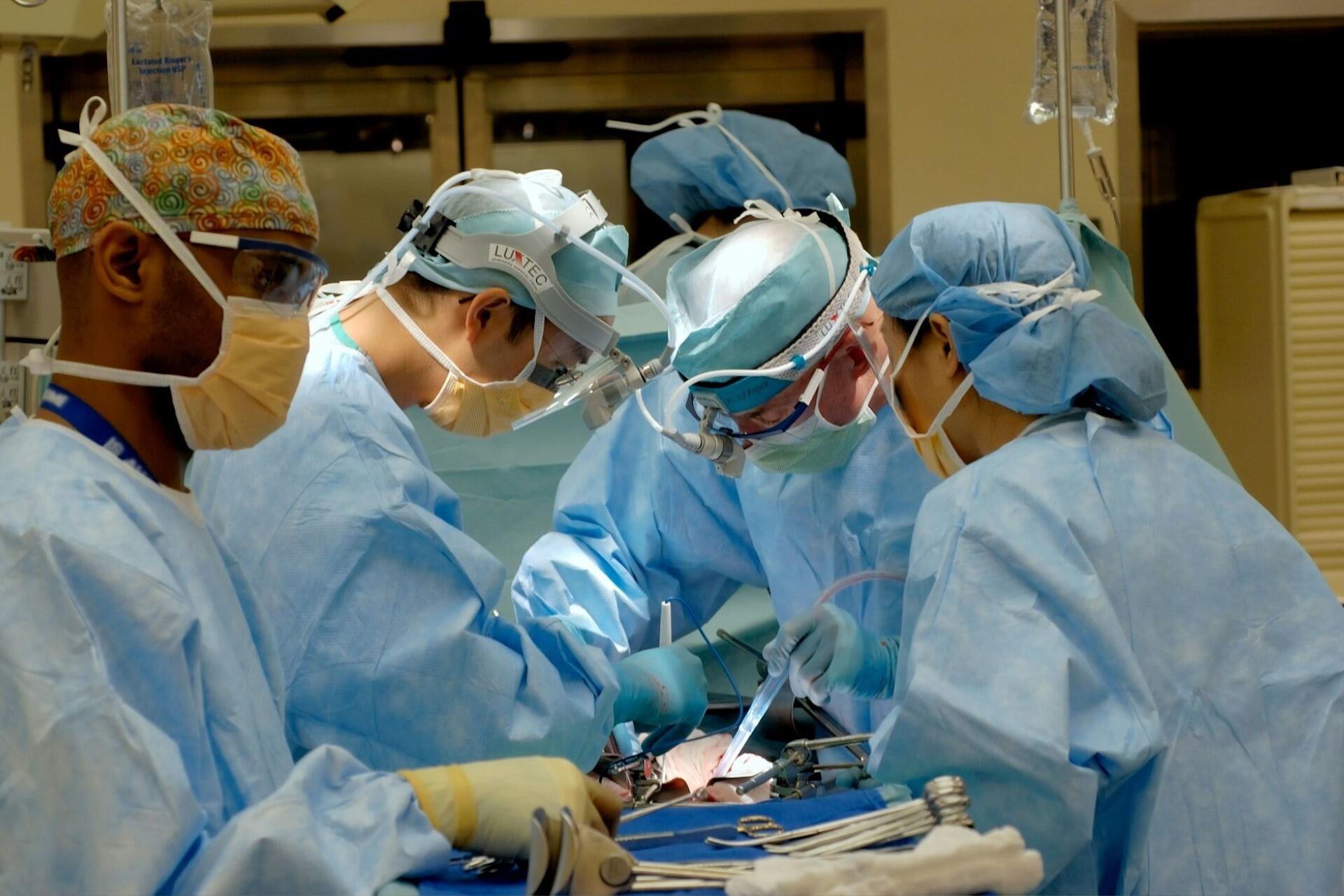 Surgical team wearing blue scrubs and masks during an operation
