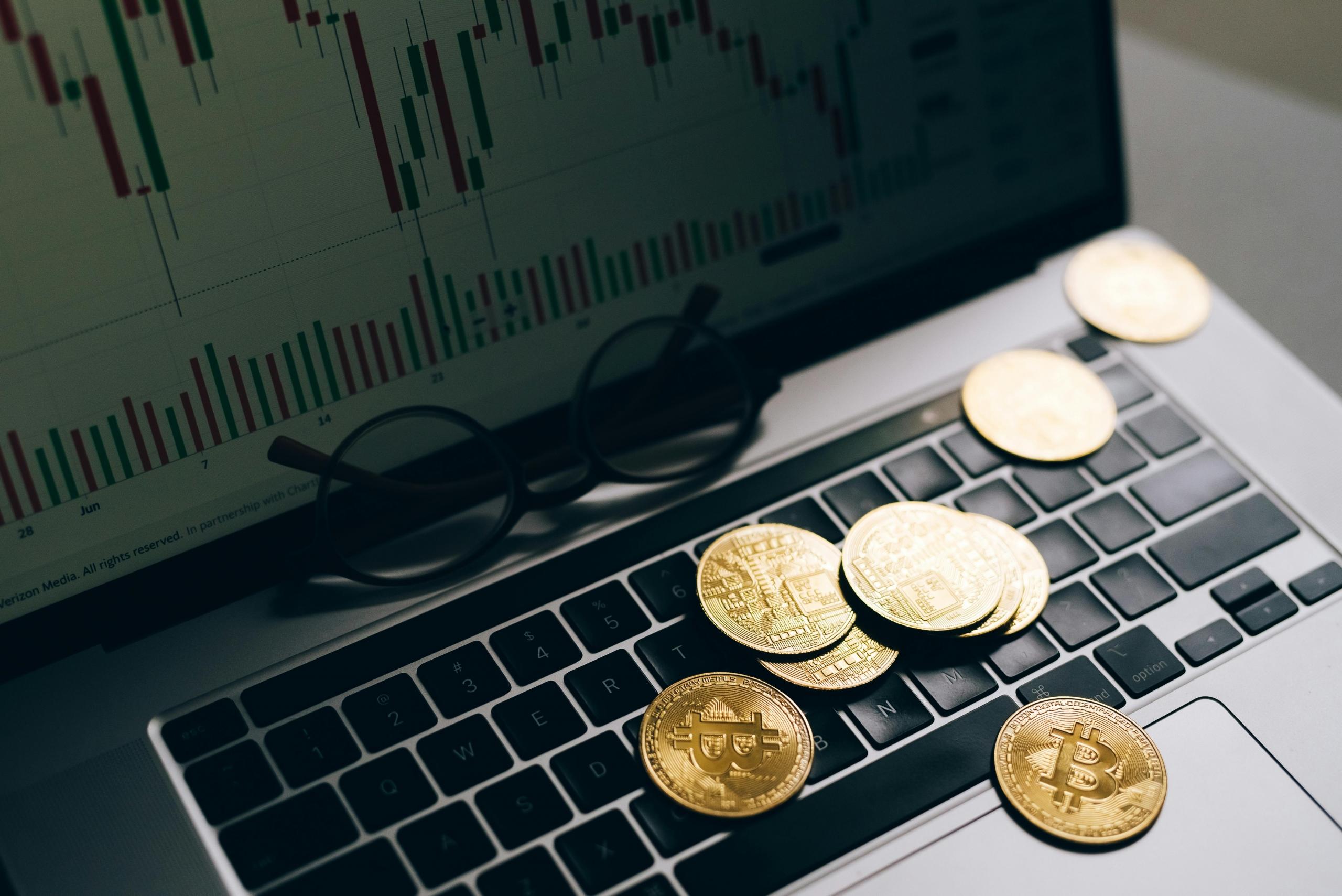 Bitcoin resting on top of a laptop