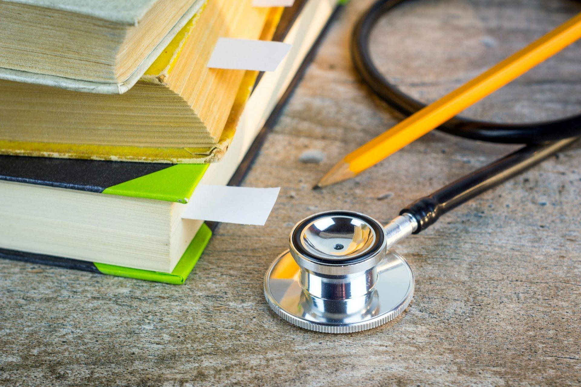 A stethoscope next to some books.