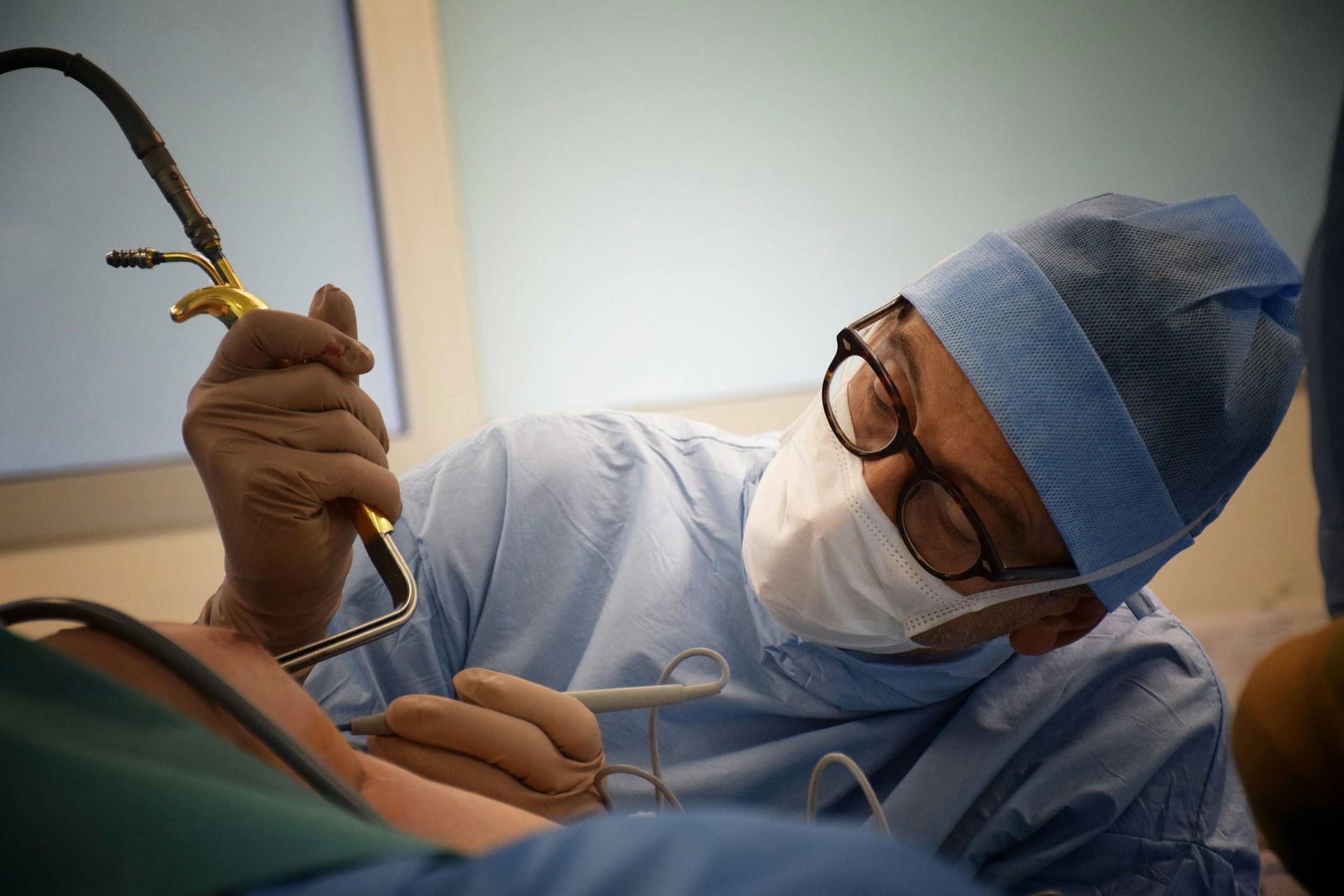 A surgeon inserting a tube.