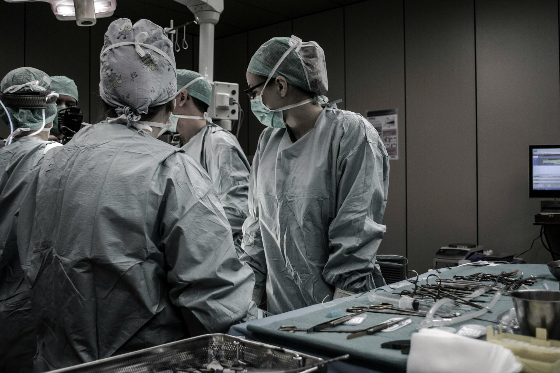 Team of surgeons wearing surgical gowns and masks in an operating theatre