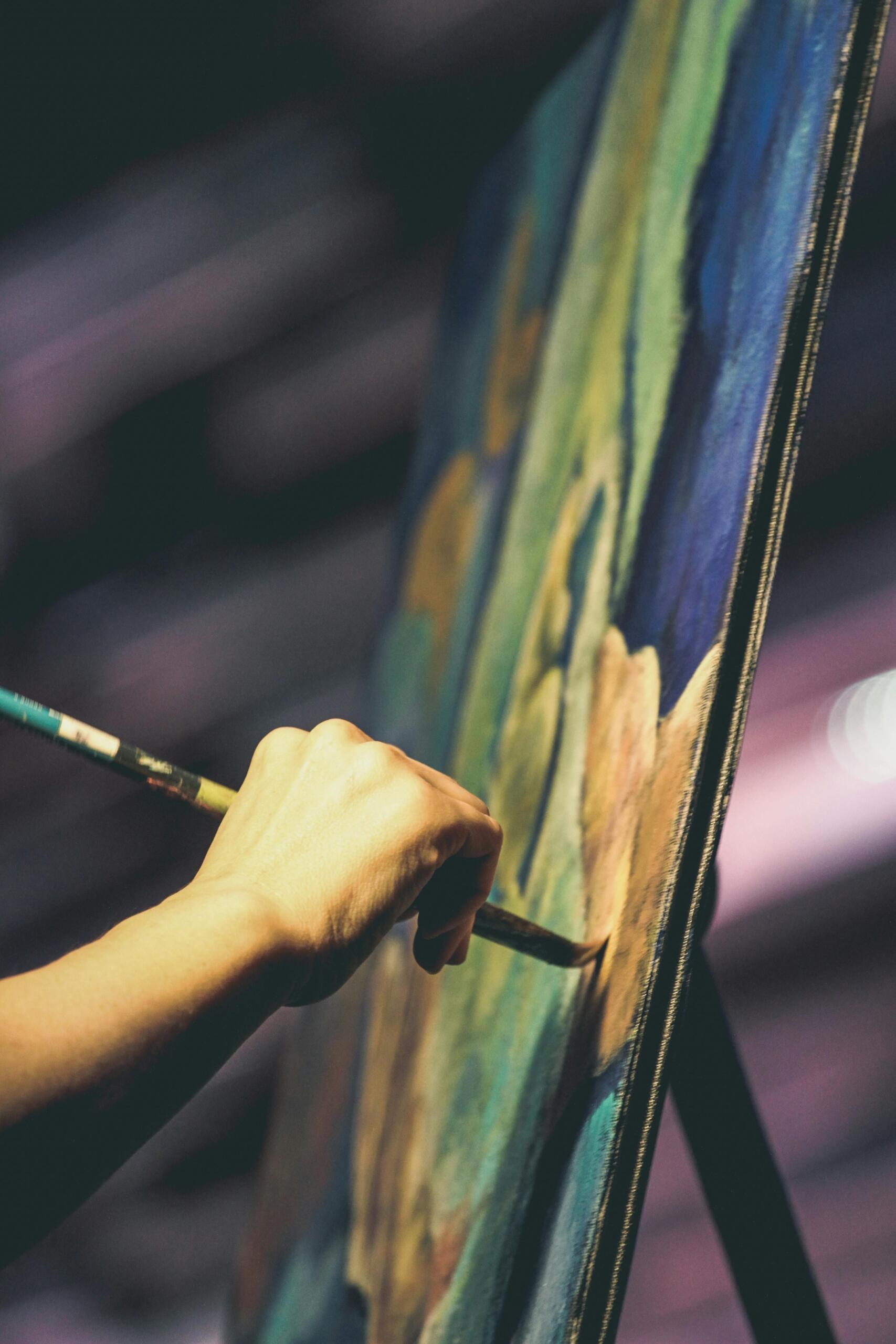An artists is painting onto a canvas