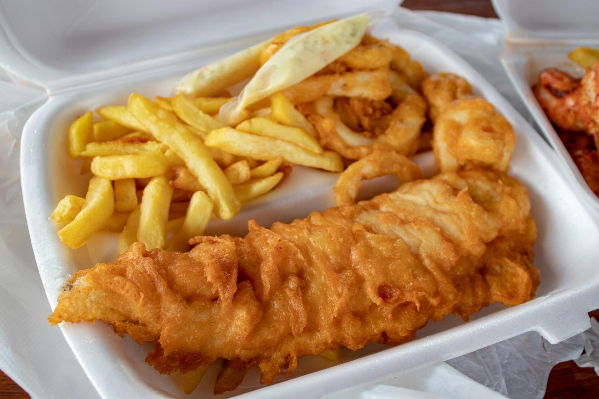 Fish and chips in a white takeaway container