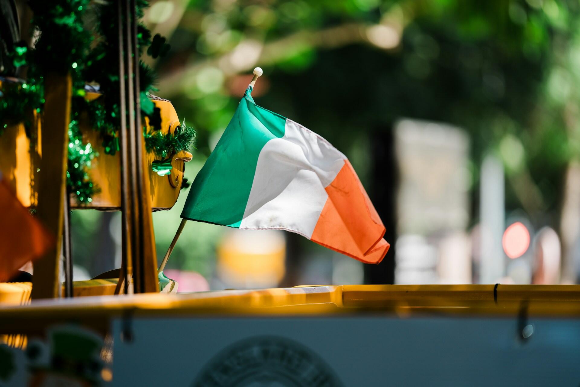 small Irish flag attached to a structure with blurred background