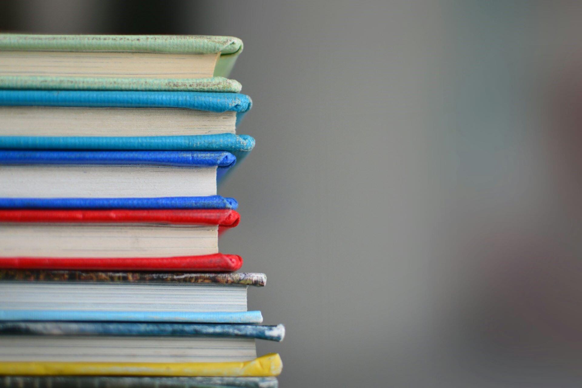 Stack of school books against a grey background