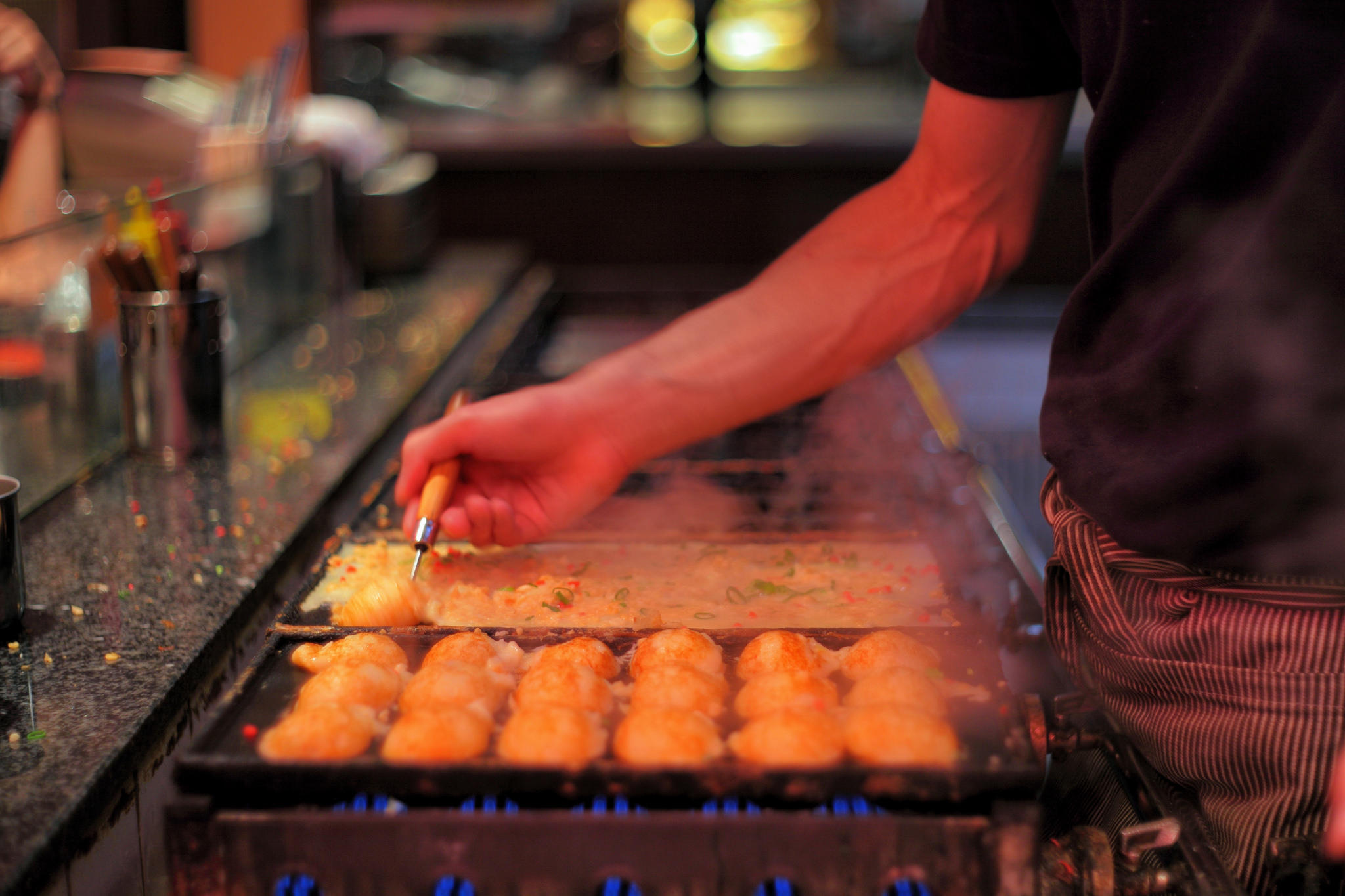 A chef doing Takoyaki style cooking.