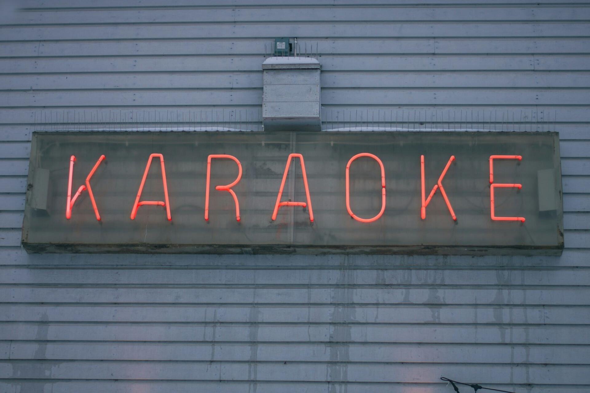 A karaoke sign on the wall of a bar.