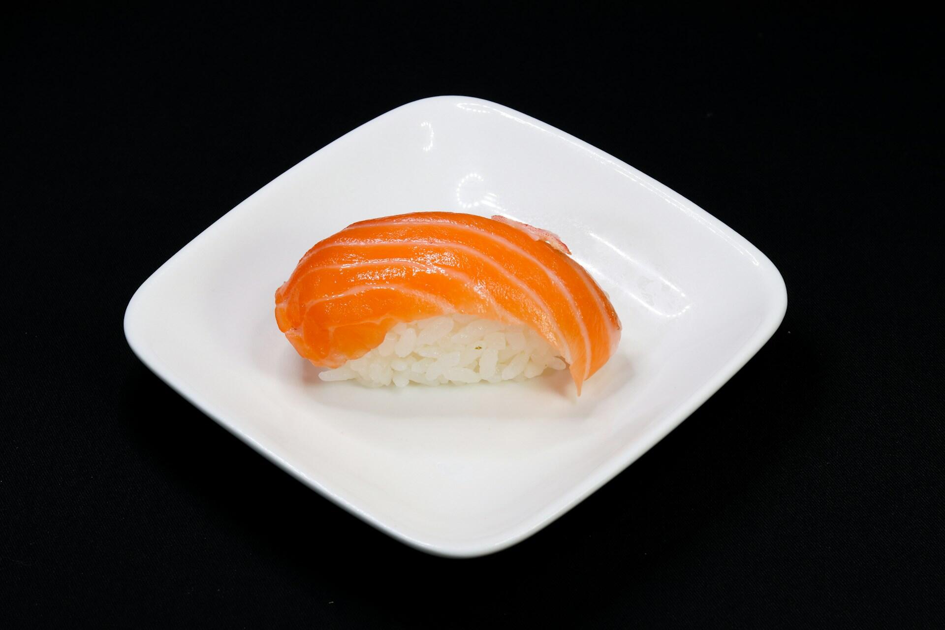 A plate with salmon sushi on it.