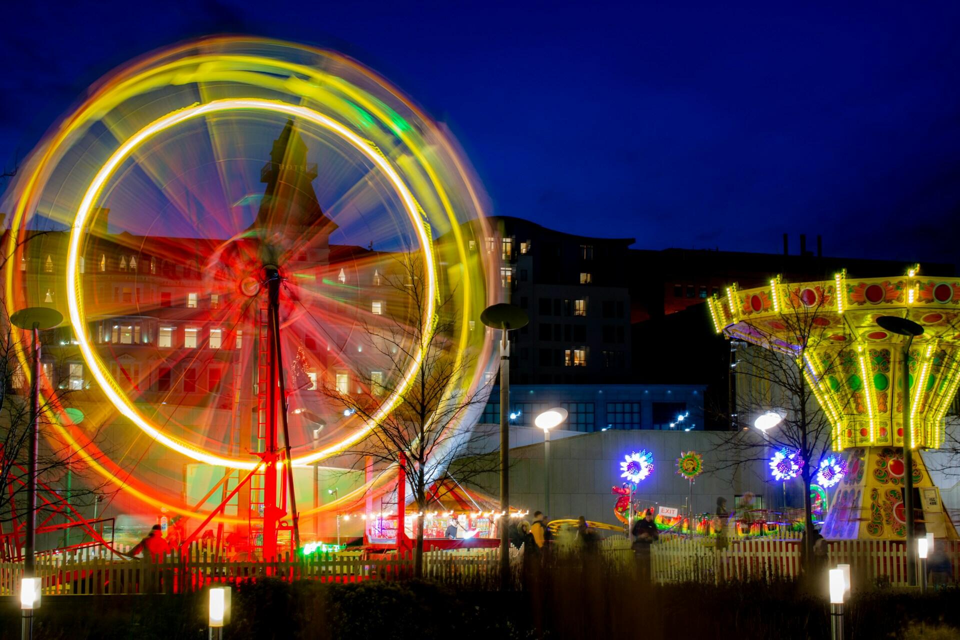 colourful fairground ride spinning at night with bright lights and motion blur