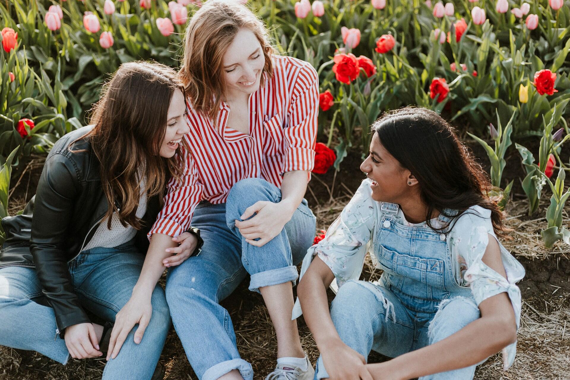Three friends sitting outdoors and talking together