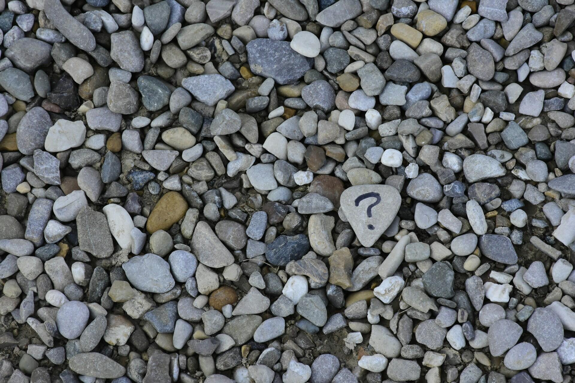 stone with question mark among pebbles