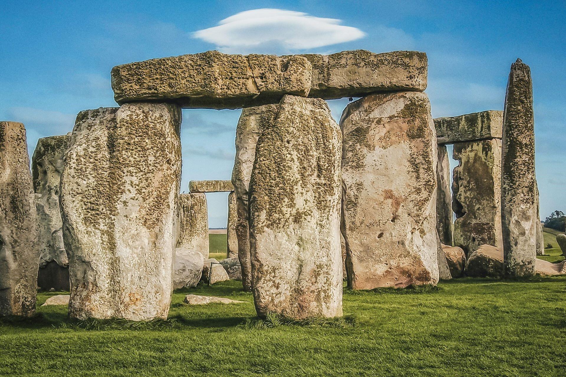 Large prehistoric standing stones and lintels at Stonehenge under a blue sky