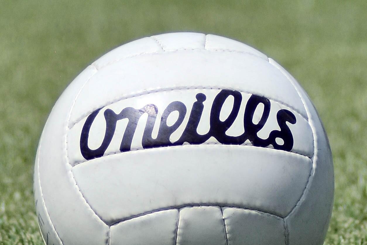 White Gaelic football resting on a grass pitch