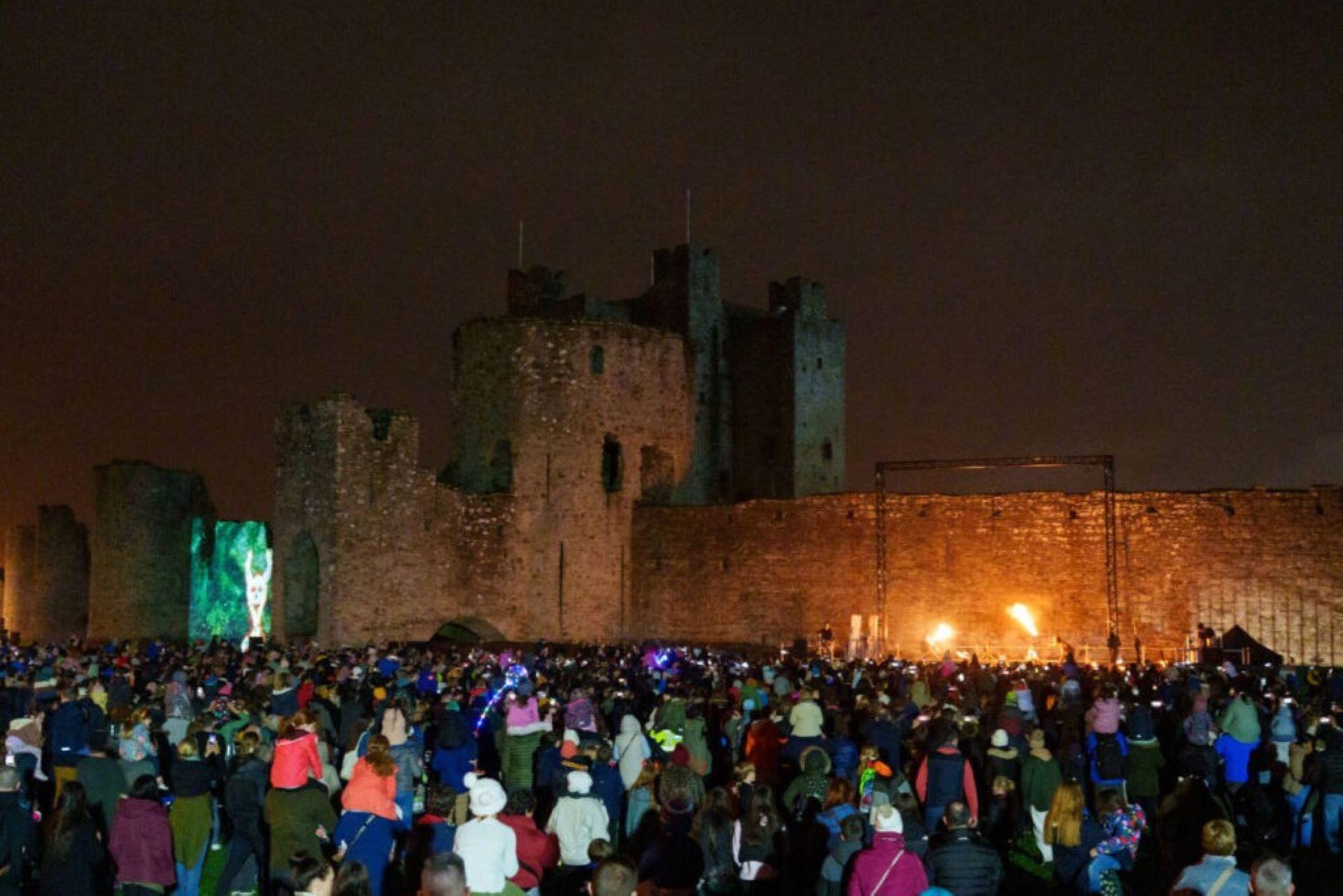 Crowd gathered outside Trim Castle during Púca Festival at night