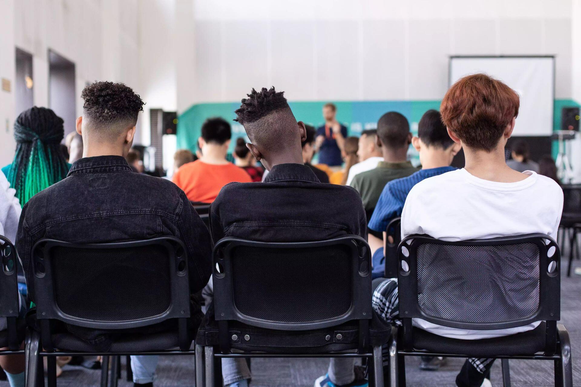 Students seated in a classroom with their backs to the camera