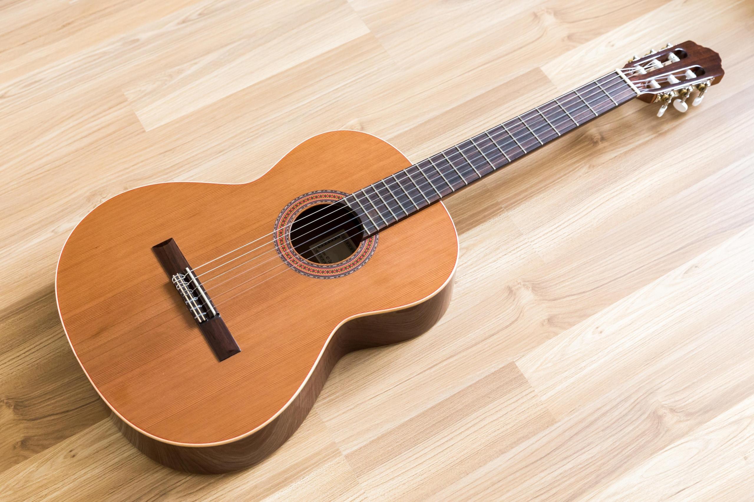 גיטרה מונחת על ריצפת פרקט